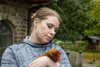 Tierschutzlehrerin kuschelt mit Henne